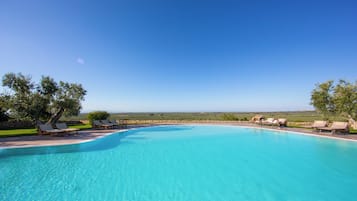Alberca al aire libre y camastros