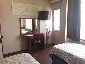 A hotel room with a bed, a desk with a chair, a television, a window with curtains, and a wall-mounted artwork. - Hotel Kadiköy Kervansaray (Istanbul)