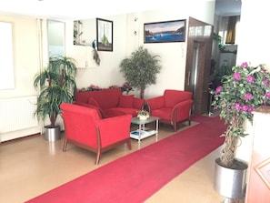 A living room with a red carpet, red sofas, a coffee table, and potted plants. - Hotel Kadiköy Kervansaray (Istanbul)