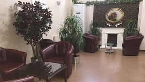 Una sala de estar con sofás de cuero, una mesa de centro de vidrio y plantas en macetas.