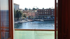 A view of a marina with boats docked, buildings in the background, and a clear sky. - Garda Sol Apart-hotel Beauty & SPA (Toscolano Maderno)