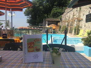 Un espace aménagé au bord de la piscine, avec une table, des chaises et un menu.