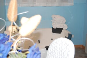 A bathroom with a bathtub, a towel rack, and a toilet.