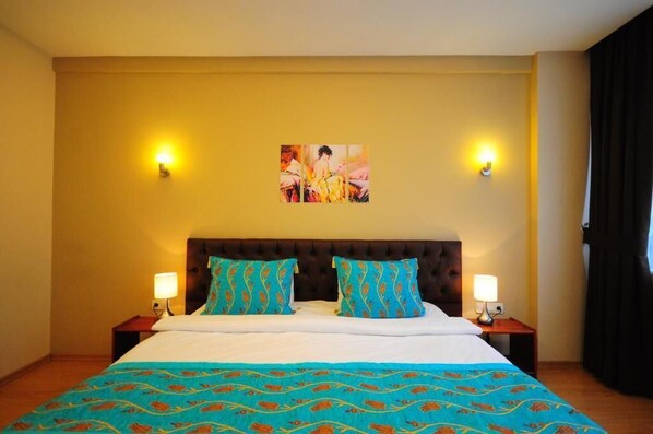 A hotel room with a large bed, two nightstands, a headboard with tufting, and two wall-mounted lamps. - RETROPERA (Istanbul)