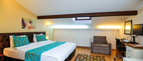 A bedroom with a large bed, a desk, a chair, and a television.