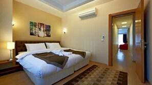 أغطية فراش متميزة وخزنة داخل الغرفة ومكتب وستائر تعتيم