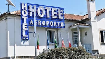 Un letrero de hotel con banderas y una antena parabólica.