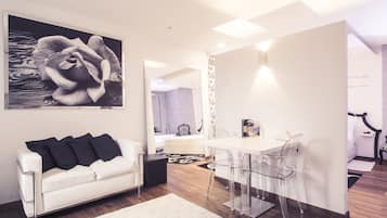 Suite Deluxe, vista a la ciudad | Área de sala de estar | Televisión de pantalla plana