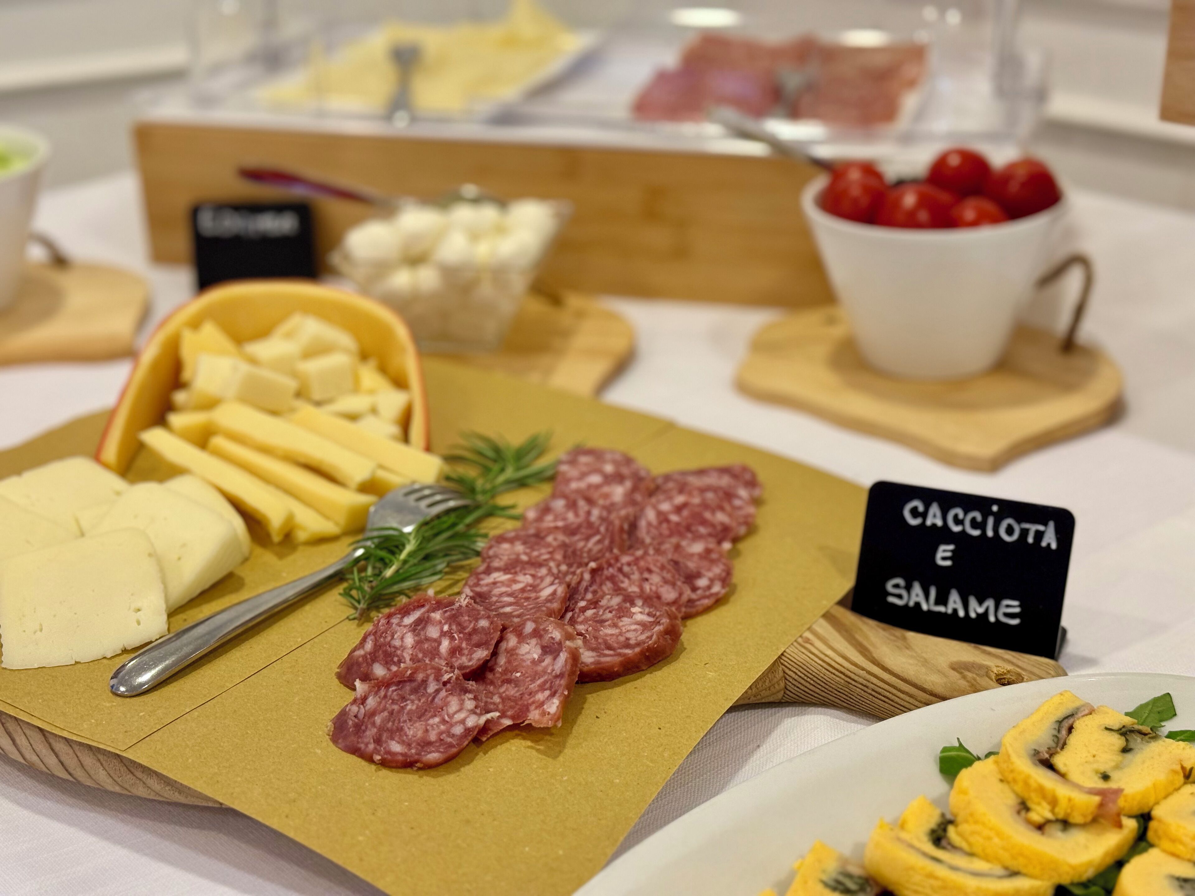 Una tabla de fiambres con diferentes carnes, quesos y acompañamientos.