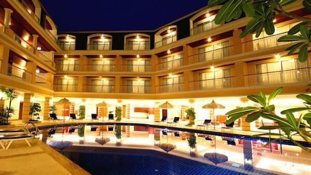 A multi-story hotel with a central pool area, multiple balconies, and indoor plants. - Kalim Resort (Patong)