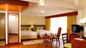 A hotel room with two beds, a desk, a chair, a television, and a window with curtains. - Kalim Resort (Patong)