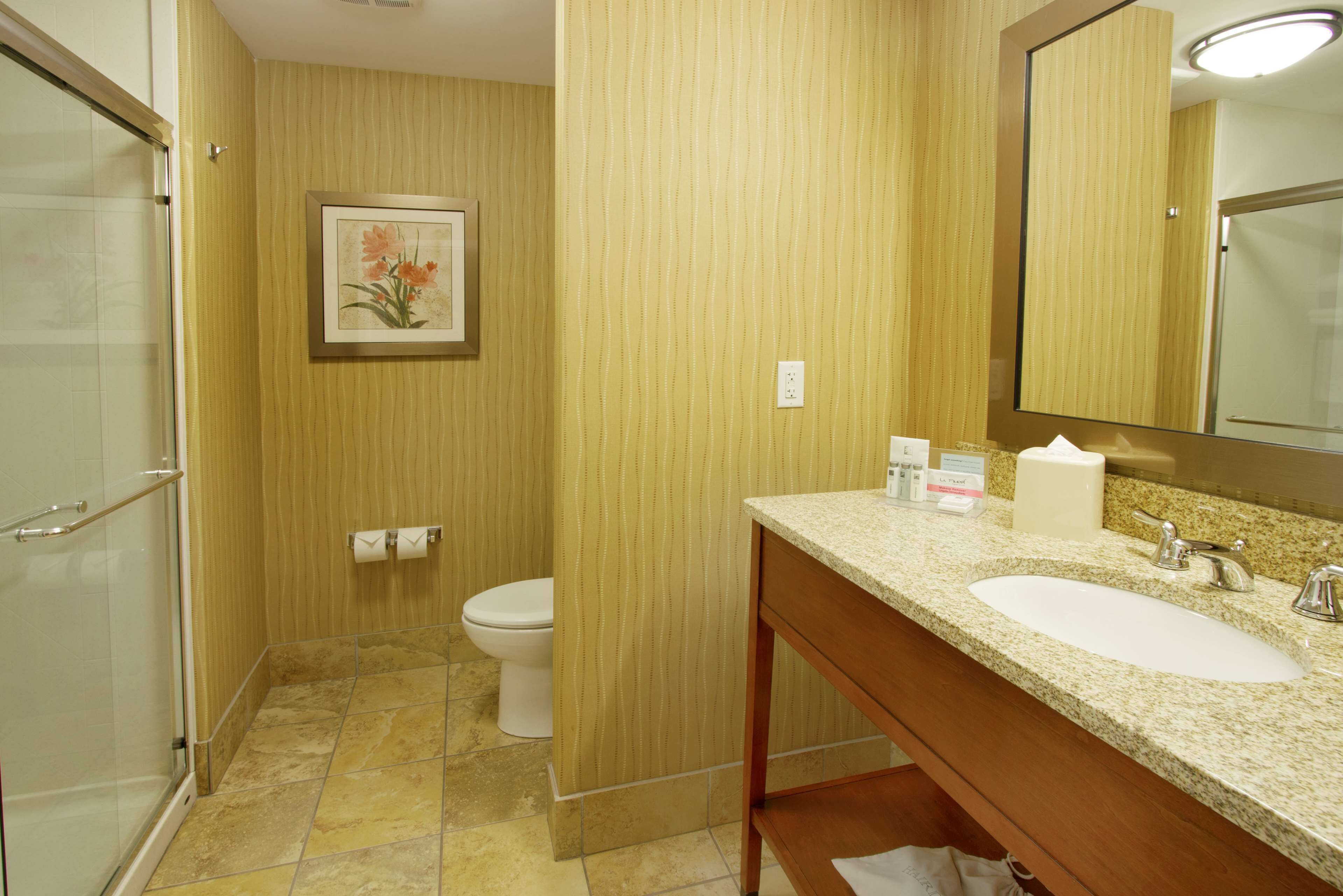 Une salle de bain avec douche, toilettes et lavabo.