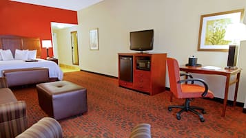 A hotel room with a bed, a desk, a television, and a chair.