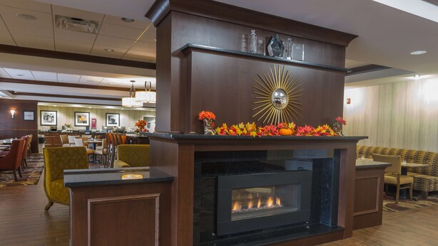 Un hall con chimenea, zona de estar y mostrador de recepción.