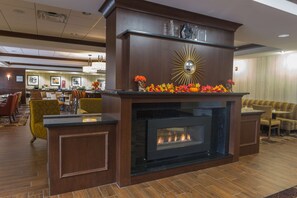A lobby with a fireplace, seating area, and a reception desk.