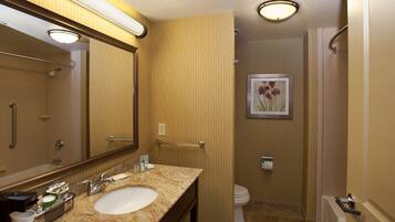 A bathroom with a sink, mirror, towel rack, and toilet.