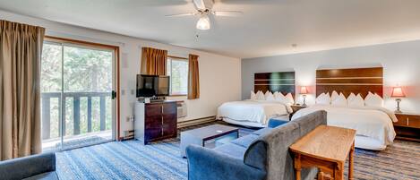 A hotel room with a large bed, a sofa, a desk, a television, and a balcony with curtains.