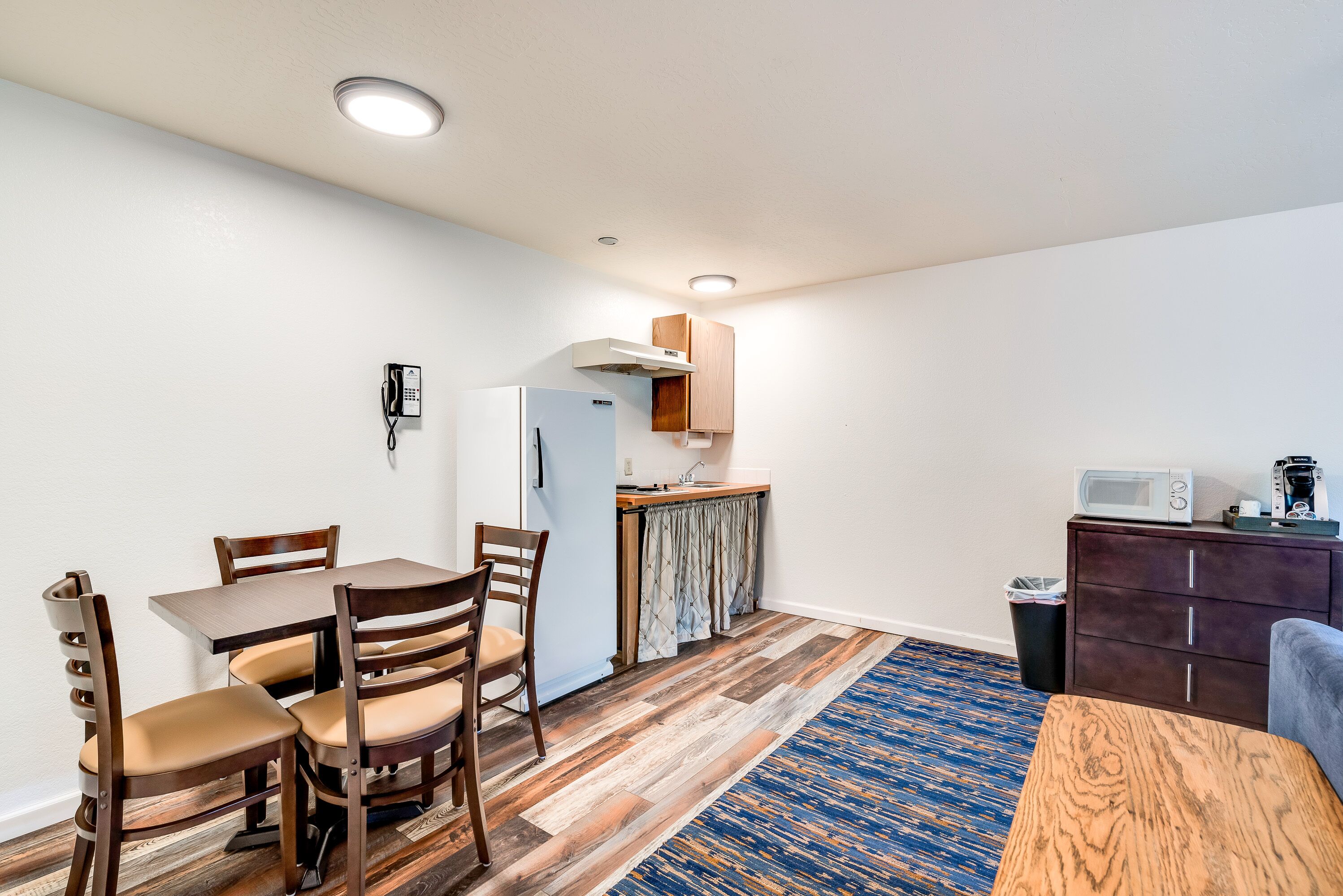 A compact living space with a dining area, kitchenette, and a small seating area.