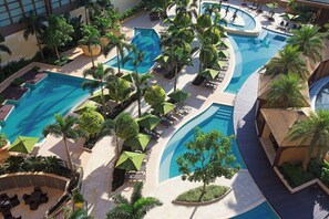 A resort with multiple swimming pools, lounge areas, and palm trees. - Londoner Grand, a Luxury Collection Hotel, Macao (Cotai)