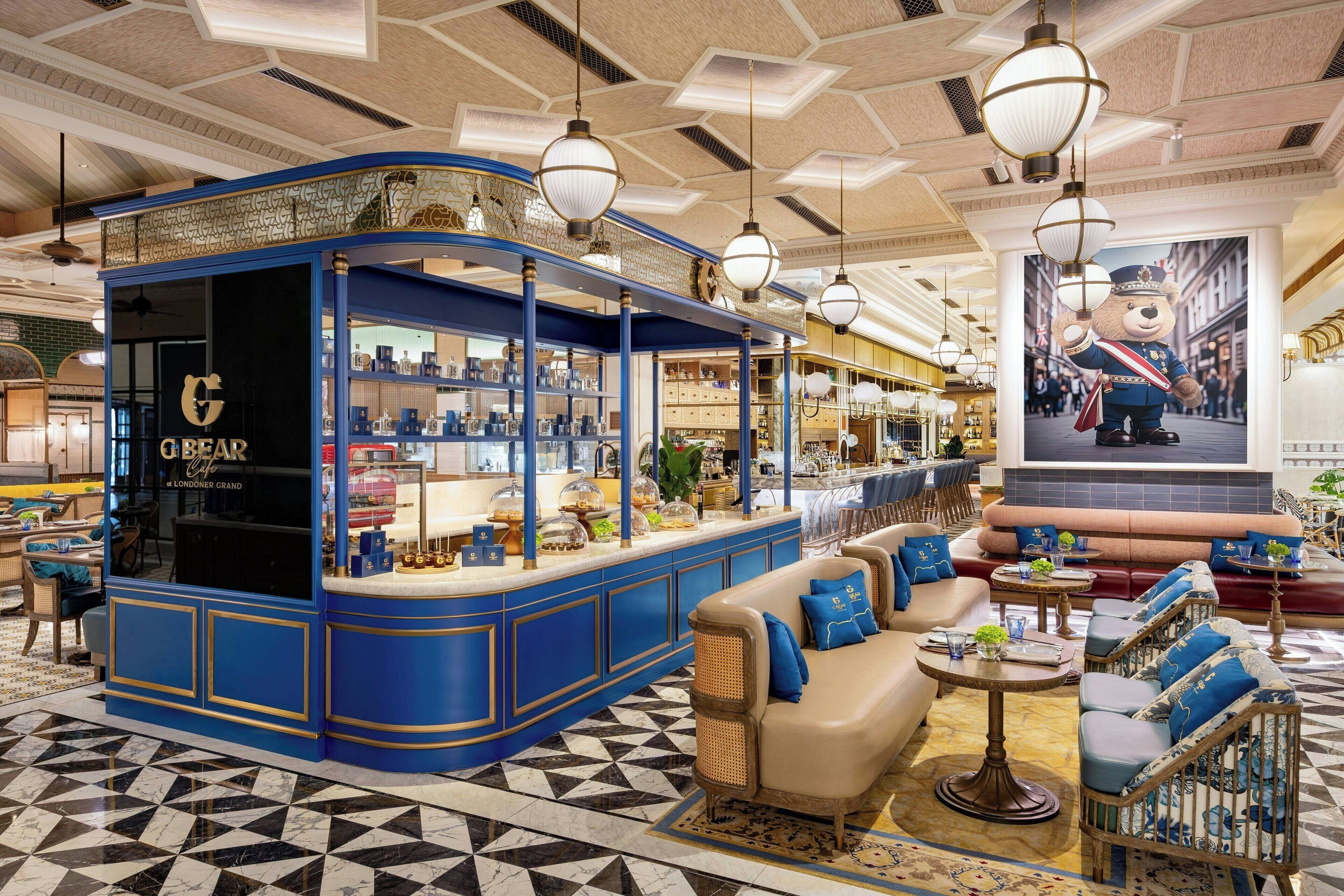 A bar area with a blue and gold color scheme, a seating area with sofas and armchairs, and a large poster of a bear on the wall.
