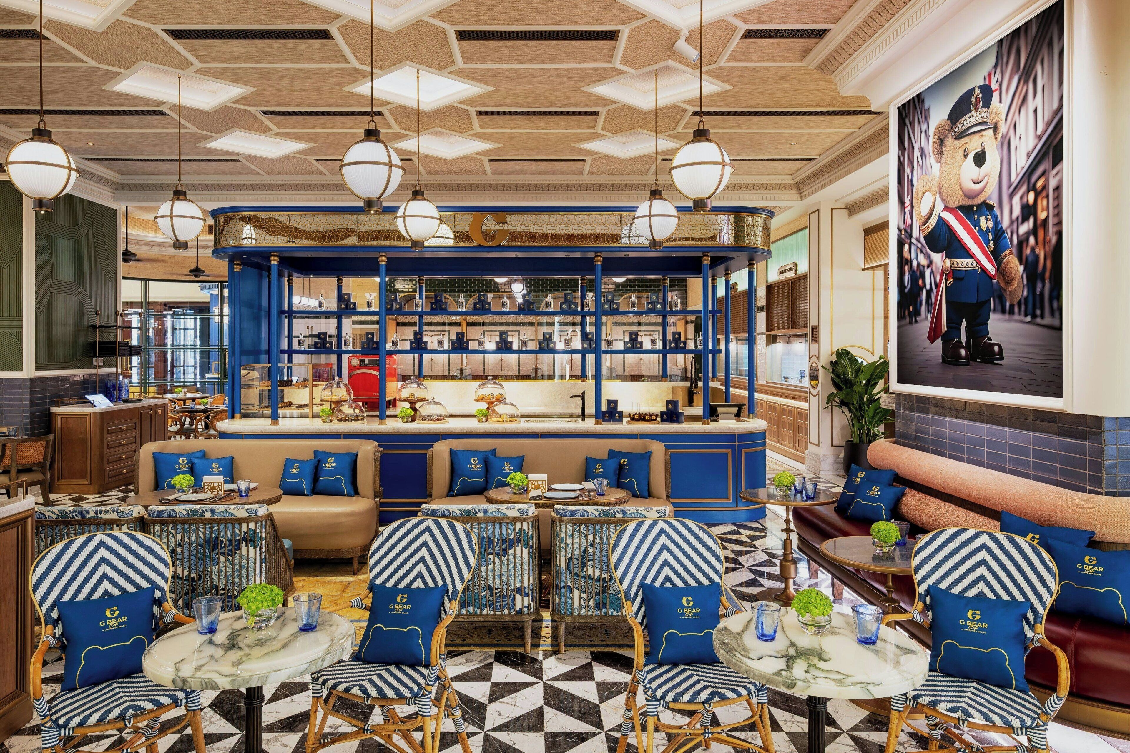 A hotel lobby with a central seating area, a bar, and a large bear mural.