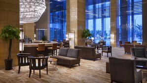 A spacious lobby with a bar, seating area, and large windows offering a view of the cityscape. - Four Points by Sheraton Suzhou (Suzhou)
