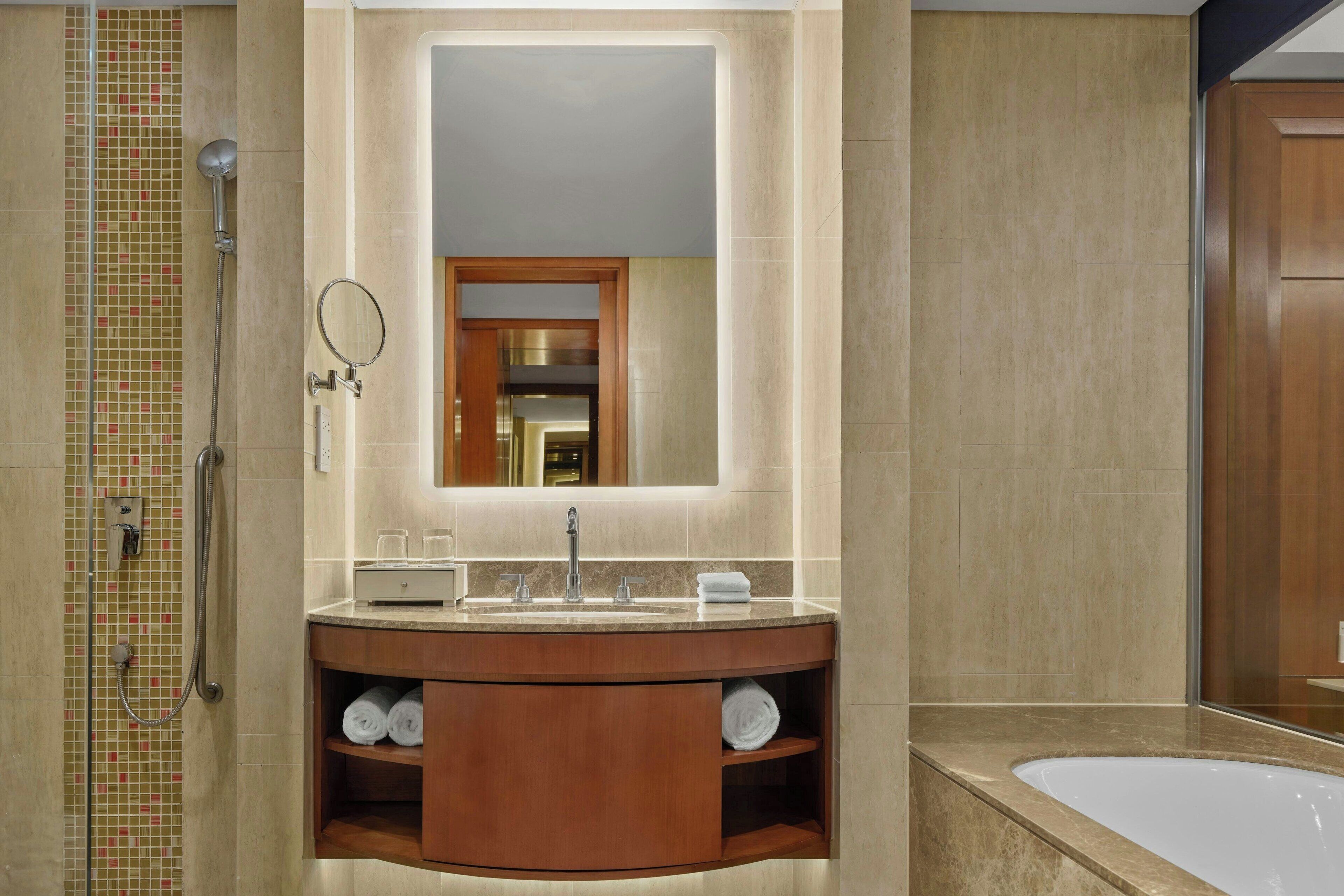 Un bagno con un lavabo, un mobile, uno specchio, una doccia e una vasca da bagno.