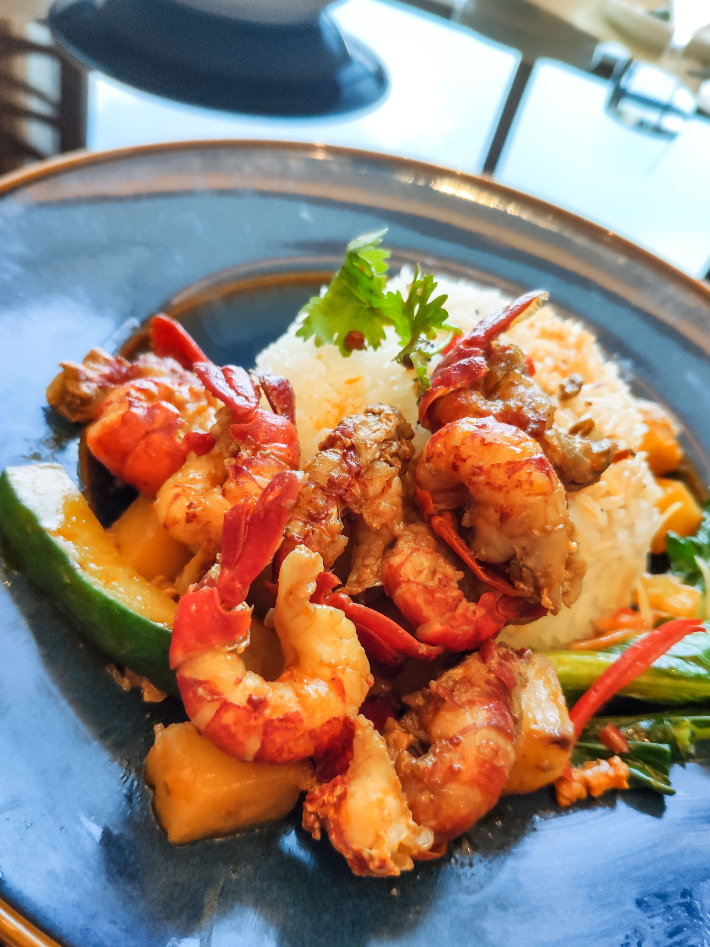 A plate of food with shrimp, rice, and vegetables.