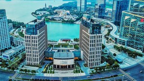 A modern urban area with a central round building surrounded by high-rise buildings and a body of water. - Four Points by Sheraton Suzhou (Suzhou)