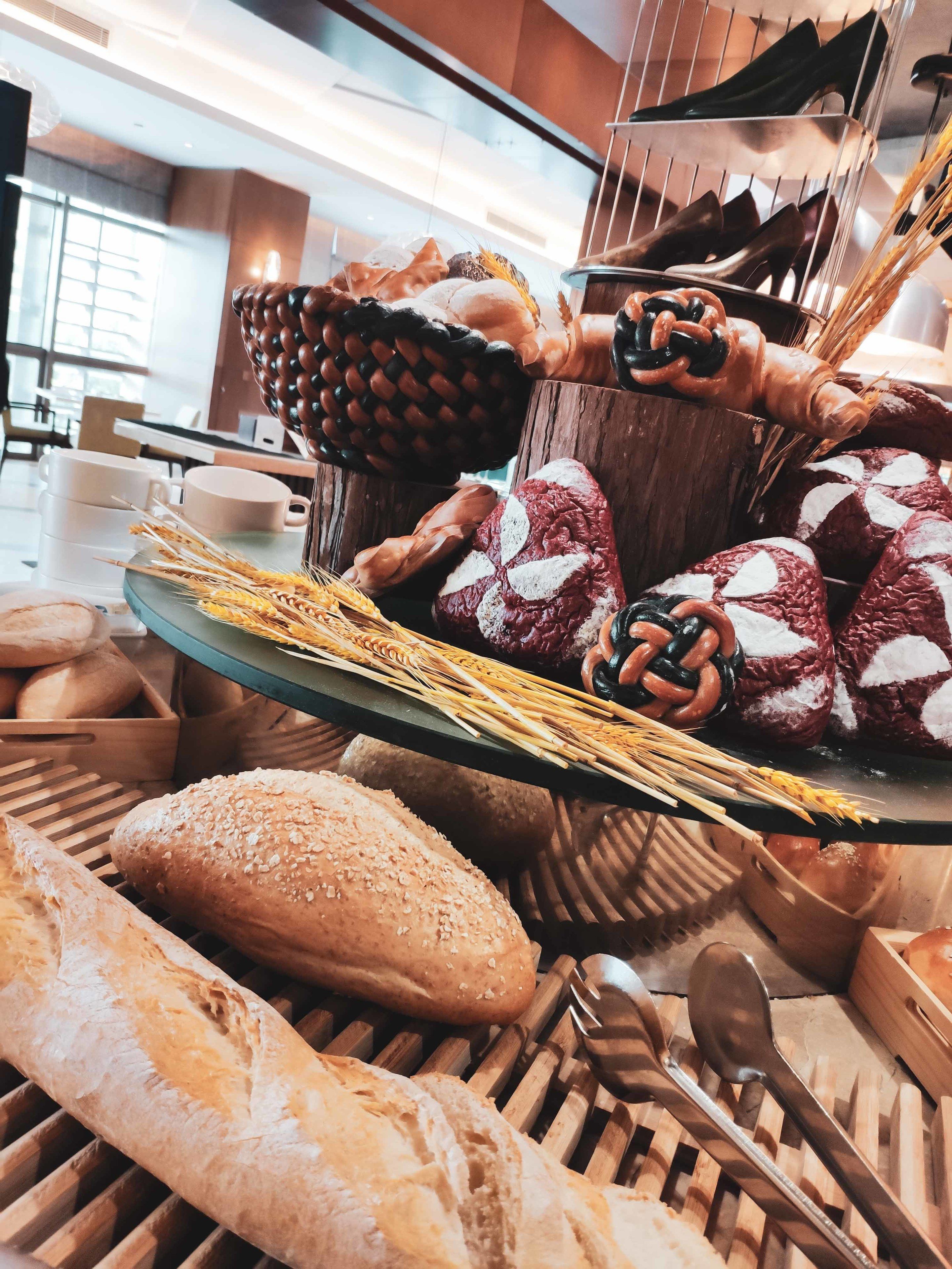 A bakery display with various breads and pastries.