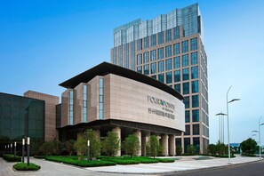 Experience the unique blend of glass and concrete architecture at this hotel, surrounded by lush greenery and well-lit streets.