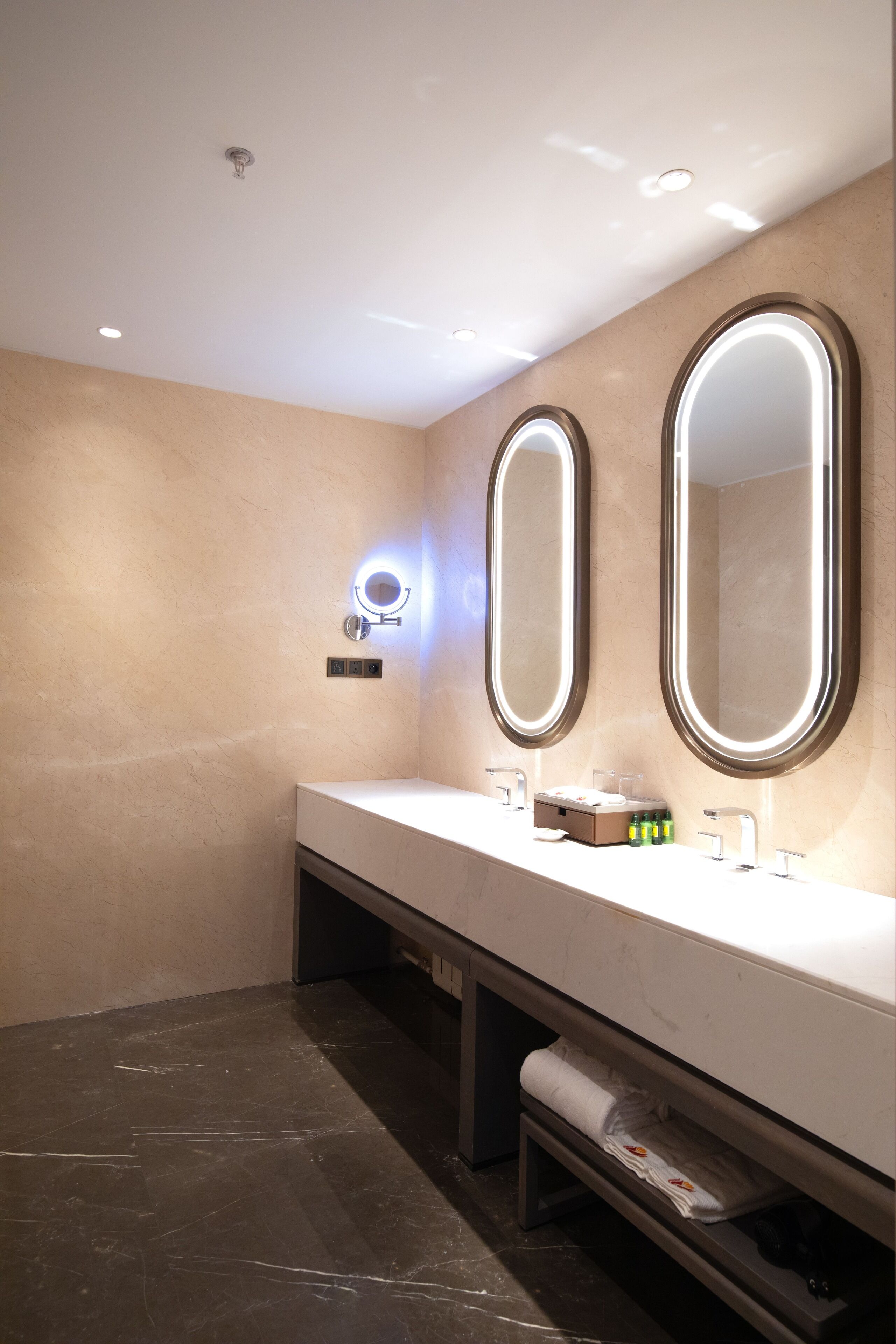 Een moderne badkamer met twee grote spiegels, een wastafelmeubel en een handdoekrek.