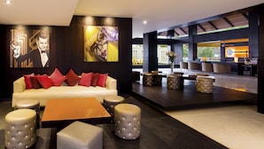A modern lobby with a sofa, ottomans, and a bar area. - Hard Rock Hotel Goa Calangute (Calangute)