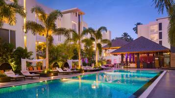 Relax by the pool surrounded by lush greenery and modern architecture.
