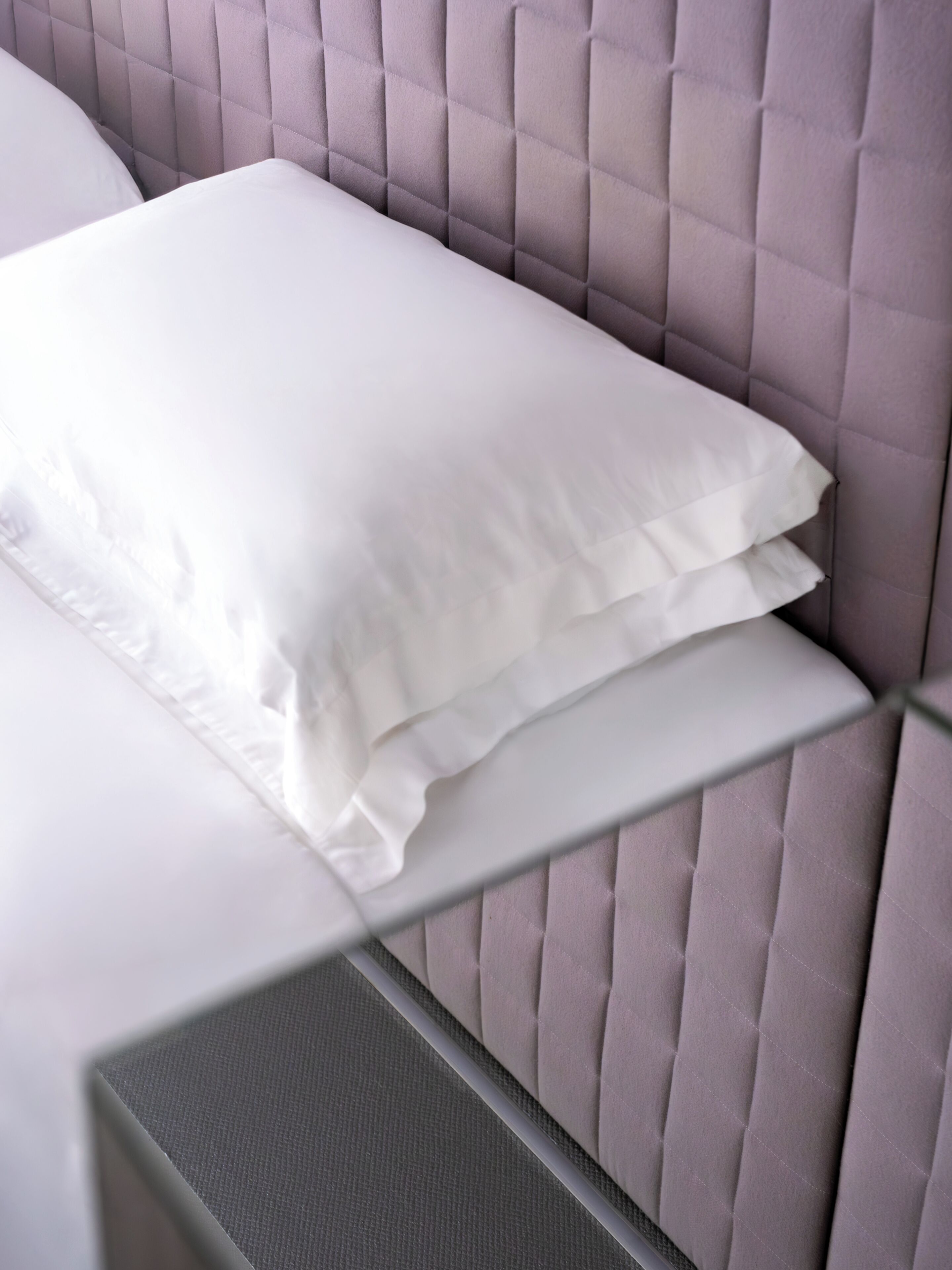 A bed with a headboard and a pillow.