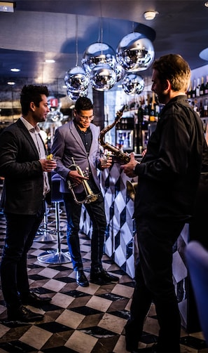 A bar with a checkered floor, hanging disco balls, and people holding drinks. - Vander Urbani Resort – a Member of Design Hotels (Ljubljana)