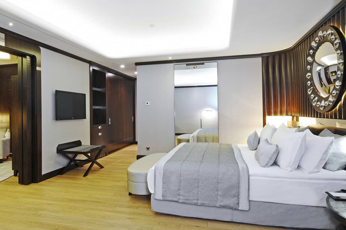 A modern hotel room with a large bed, a desk, and a seating area.