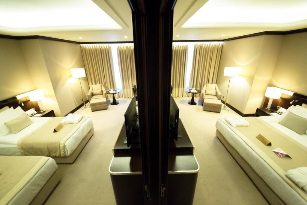 Une chambre d’hôtel avec deux lits, une télévision et un bureau.