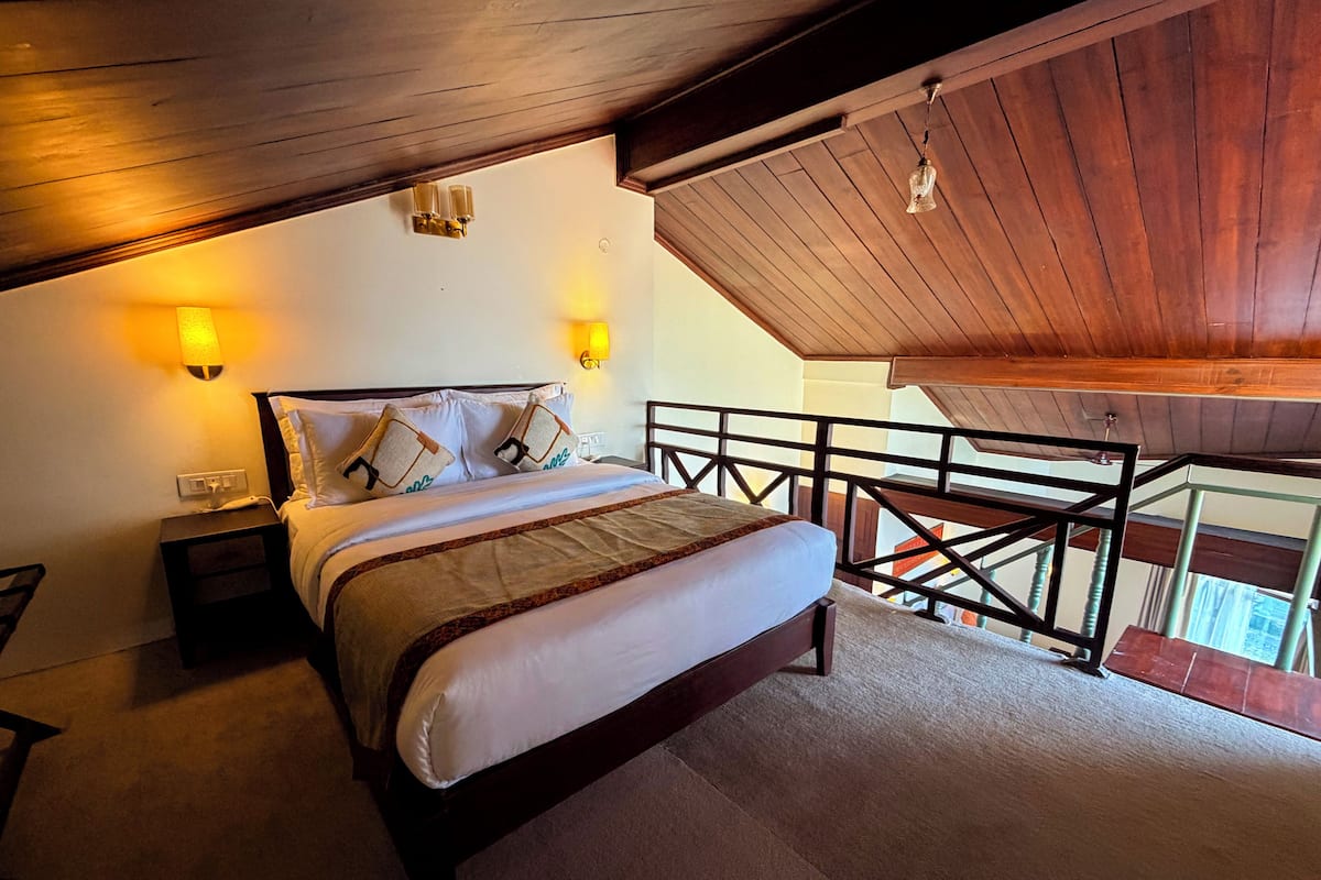 Une chambre à coucher comprenant un lit, des lampes de chevet, une table de chevet et un balcon avec une balustrade.