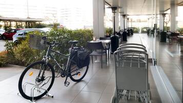 Ein überdachter Außenbereich mit einem Fahrrad und einem Einkaufswagen.
