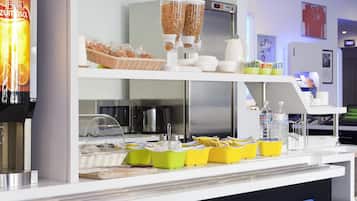 Una barra de desayuno con máquina de café, dispensadores de cereales y diversas opciones para el desayuno.