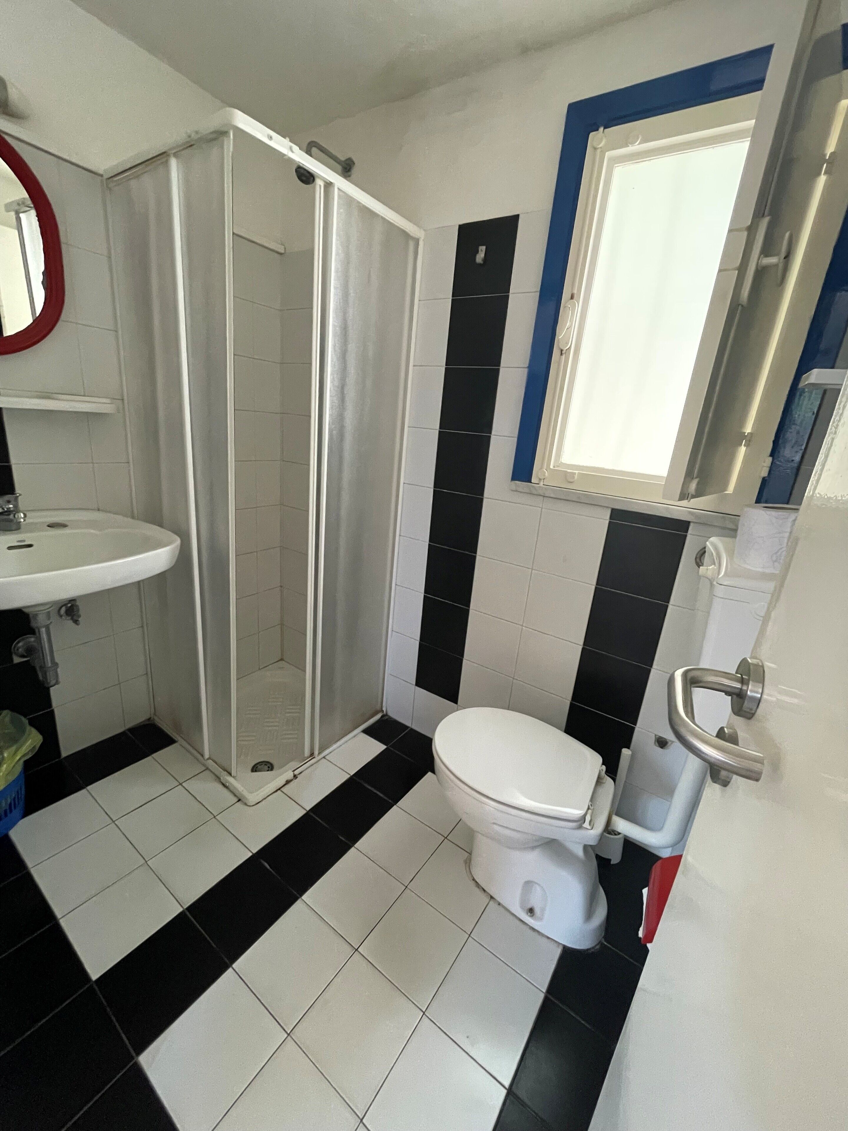 A bathroom with a white sink, a toilet, and a shower enclosure.