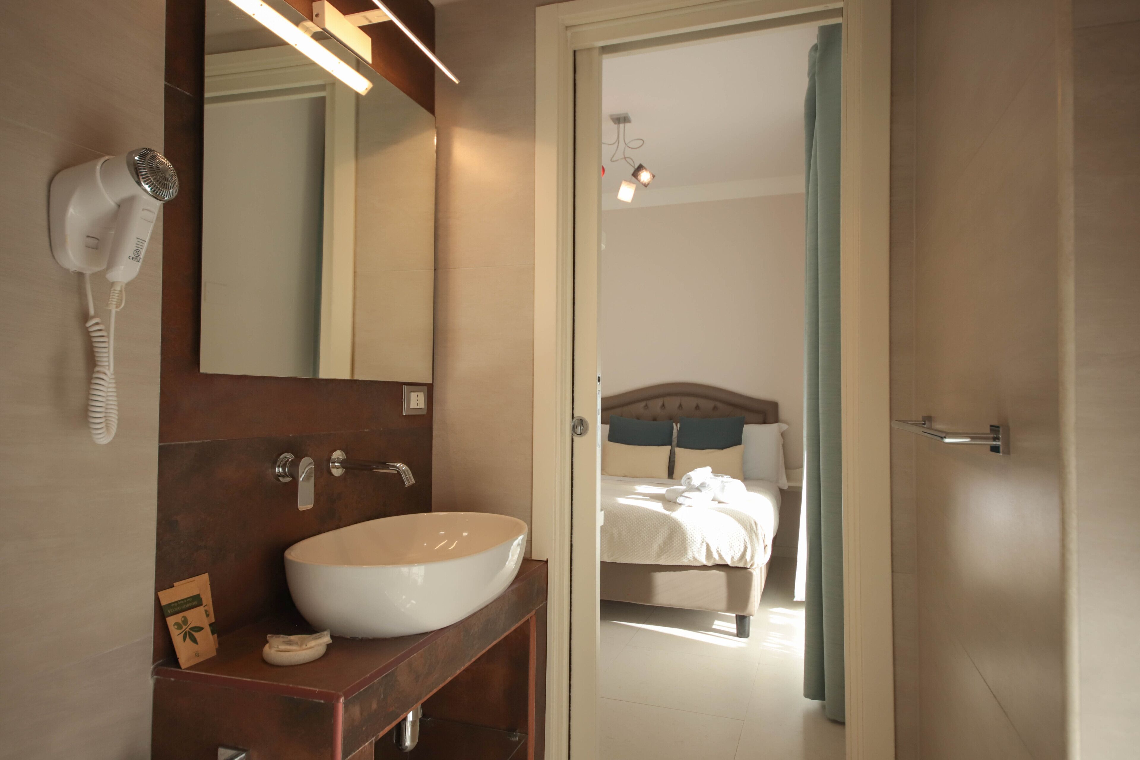 A bathroom with a large sink, a hairdryer, and a mirror.