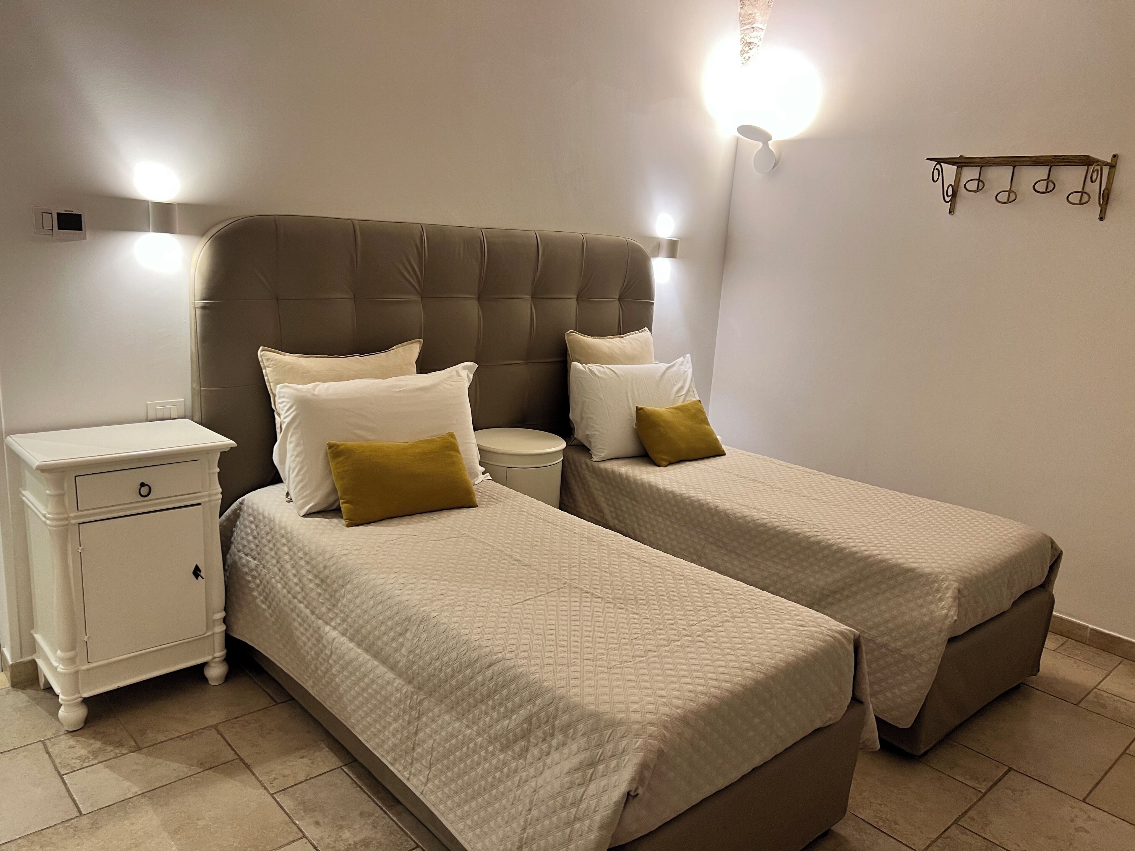 A double bed with a headboard, a bedside table, and a wall-mounted light fixture.