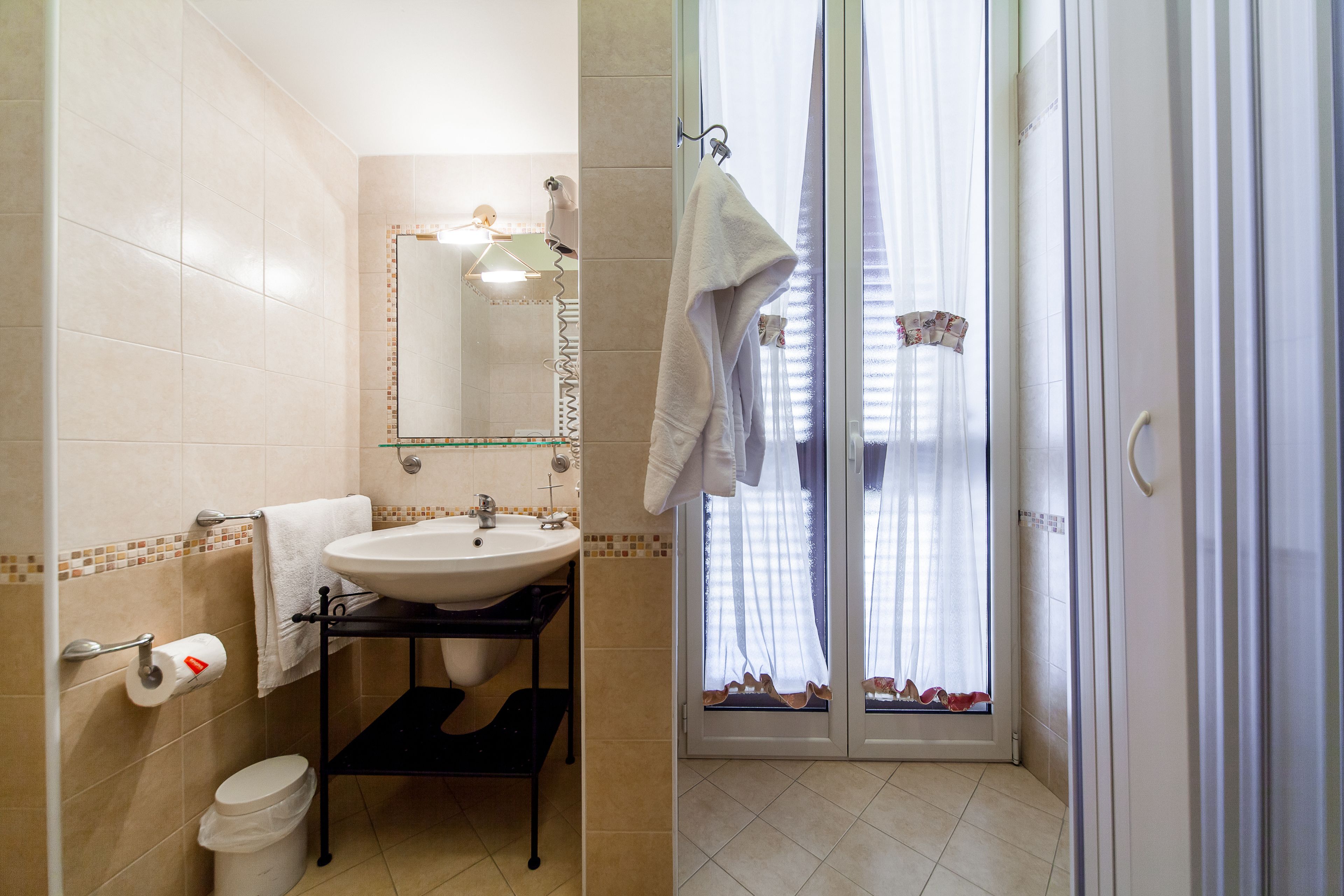 A bathroom with a sink, mirror, towel rack, and toilet.