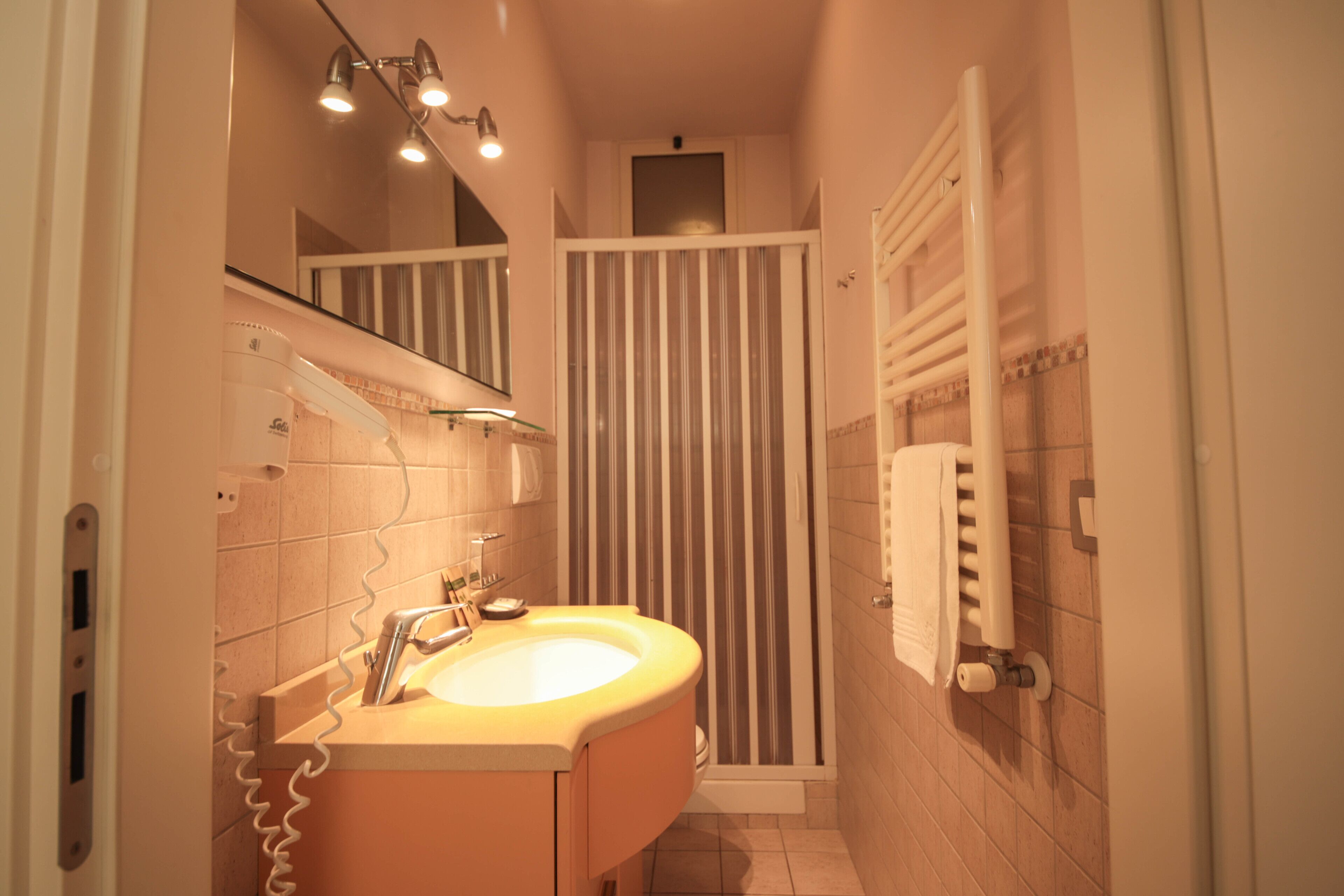 Un baño con lavamanos, espejo y cortina de ducha.