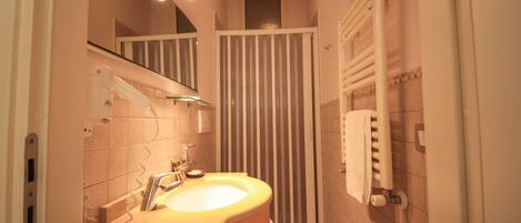 Un baño con lavamanos, espejo y cortina de ducha.