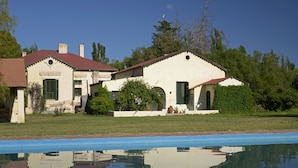 A two-story house with a swimming pool in front.