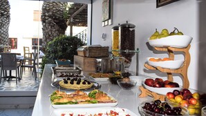 Una mesa de buffet con diversos alimentos y una presentación de frutas.