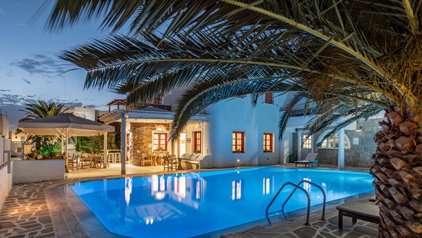 Una piscina con sillones de descanso y un deck de baldosas de piedra.
